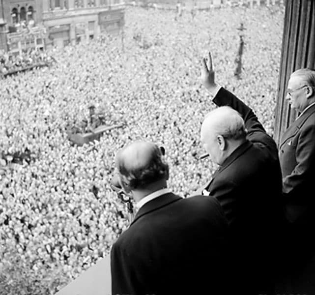 Sir Winston Churchill gives his V for Victory sign to crowds in Whitehall on the day he broadcast to the nation that the war with Germany had been won, 8 May 1945