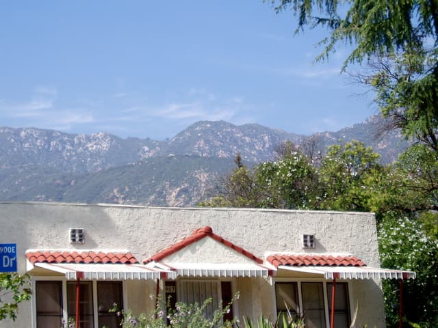 The crumbly San Gabriel Mountains behind this house can be more dangerous than they look. This is a good day, not a stormy day.