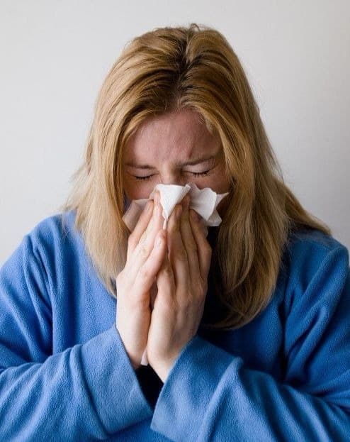 She's sick with the flu, but she's going to suffer through it and report to work anyway.