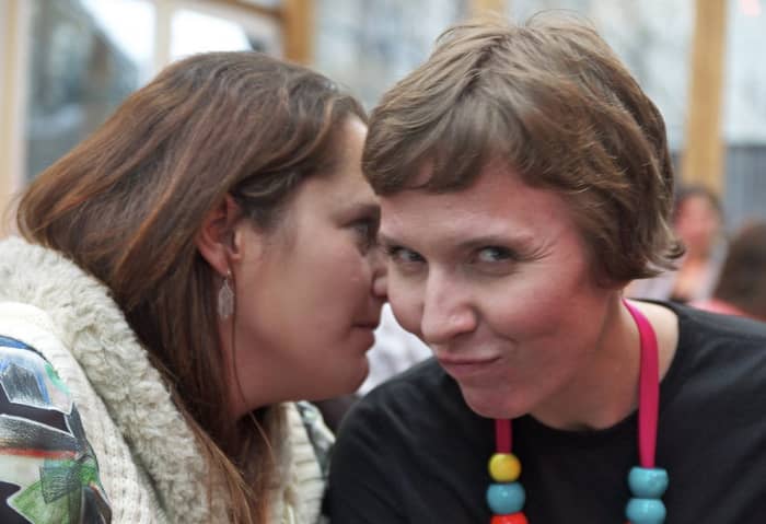 Looks like these two are whispering some juicy gossip. Persistent whispering in the workplace can be a bullying tactic.