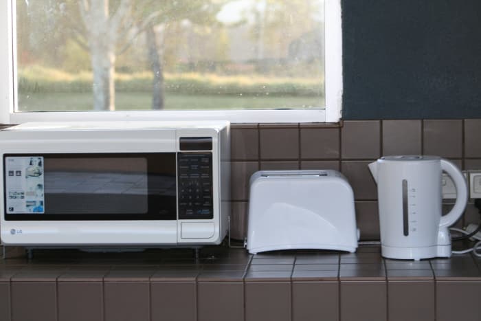 If you camp on an unpowered site in a caravan park, you'll have access to their cooking facilities. Some offer indoor and outdoor cooking options and even let you use a fridge. Choose a nice clean resort and negotiate a weekly or monthly rate.