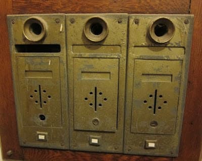 These old style apartment mailboxes, complete with speaking tubes, must have been real mailman knuckle-busters.