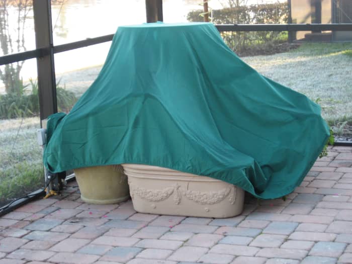 I keep the old stained, torn sheets folded in my garden storage bin. When a frost is predicted for Central Florida, I pull the sheets out to protect my plants.