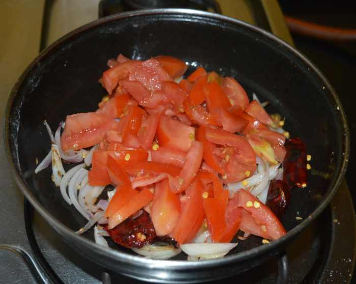 Step two: Add tomatoes and cashew nut pieces.