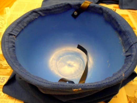 Continue to use the hot glue to attach the fabric all the way around the inside of the helmet.