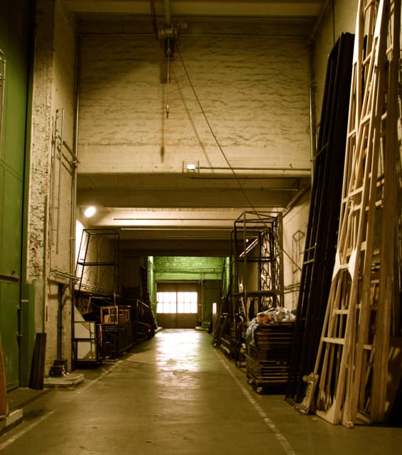 Under the side stage, elevator on the left side, sets ready to be moved on the right. Leipzig Opera.