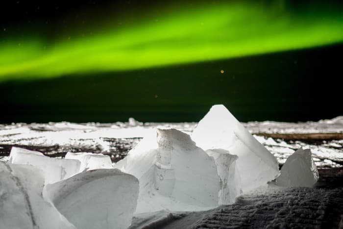 The Aurora Borealis often looks like a green curtain or drape that covers stars. It's best seen in the Arctic but is sometimes visible at lower latitudes.