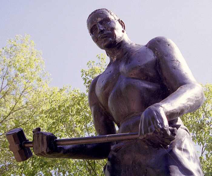 John Henry statue, near Big Bend Tunnel, WV; his story is told in the folk song heard below. Image courtesy Ken Thomas and Wikimedia Commons.