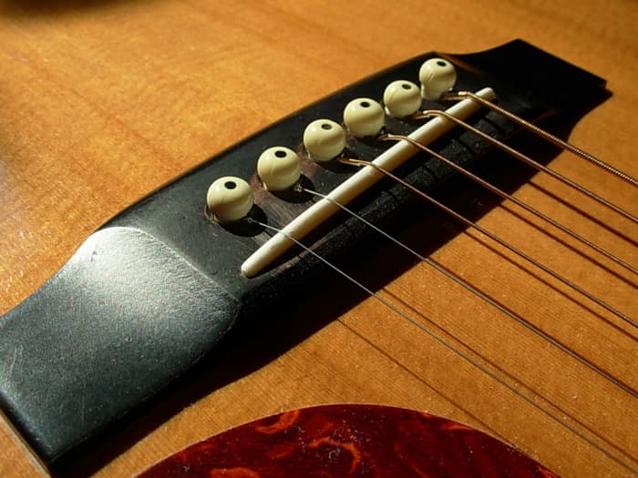 The bridge of an acoustic guitar. A safe haven for strings, and they're final destination down the long road of your guitar.