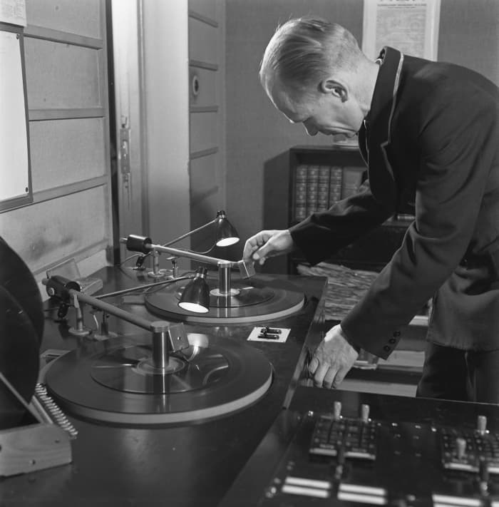 Man broadcasting records over radio.