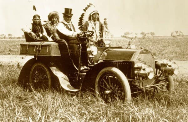 This 1905 vintage photograph of Geronimo dressed up in a suit and top hat, while riding a Cadillac inspired a great Western song.