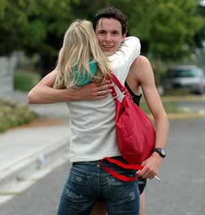 Her arms are gripping him tight, but his half-hearted embrace could indicate disinterest. Either that or he's just sweaty.