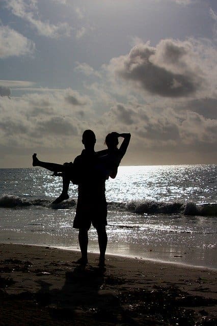 A couple frolics by the ocean as they share a life of bliss together.