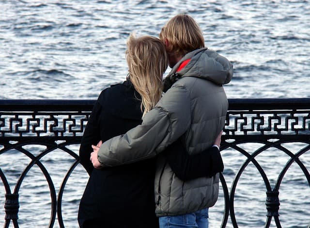 A young couple shares intimate, quiet time by the water.