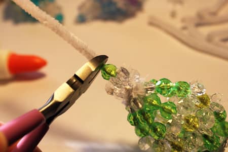 With the final glue and beads in place on the last strand, snip off the remaining portion of pipe cleaner.