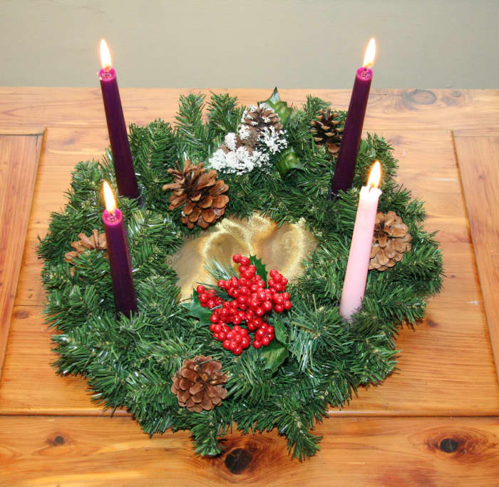 An advent wreath in the traditional Catholic colors. Most of Advent is purple for penitence, with a break in the third week for the rose light of joy.