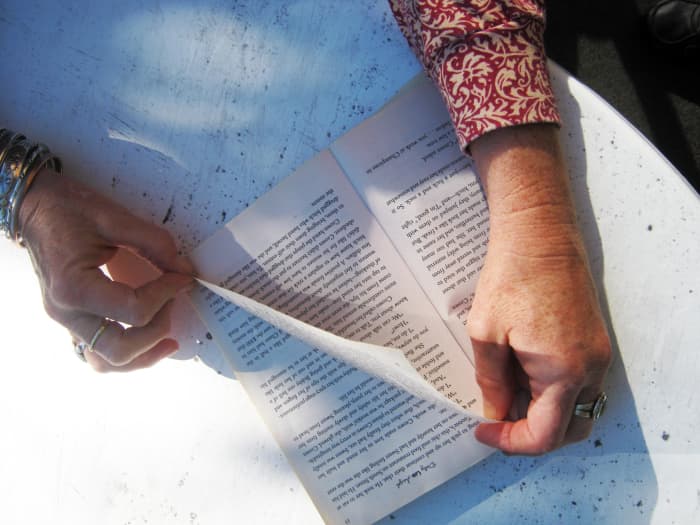 Remove the book's cover and fold the page with a diagonal crease from the top edge nearest the binding to the bottom outside edge.