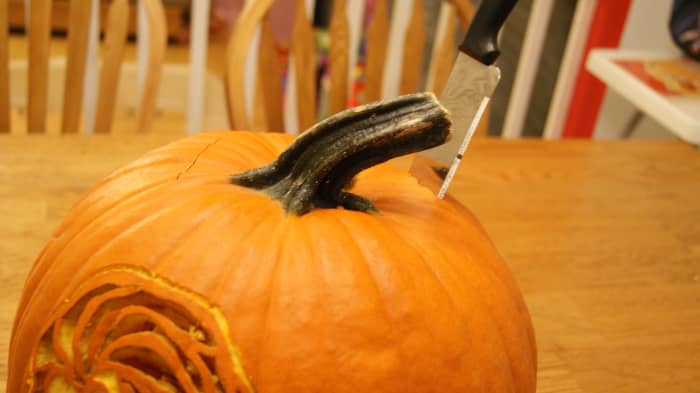 When cutting the lid of a pumpkin go in at an angle to the pumpkin and make the cuts an odd shape