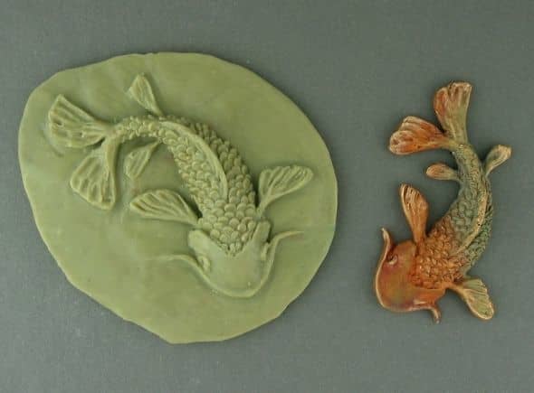 Bronze Koi with the mold in which it was formed; you can see the clay shrinkage in the difference in size between the mold and the fired piece.