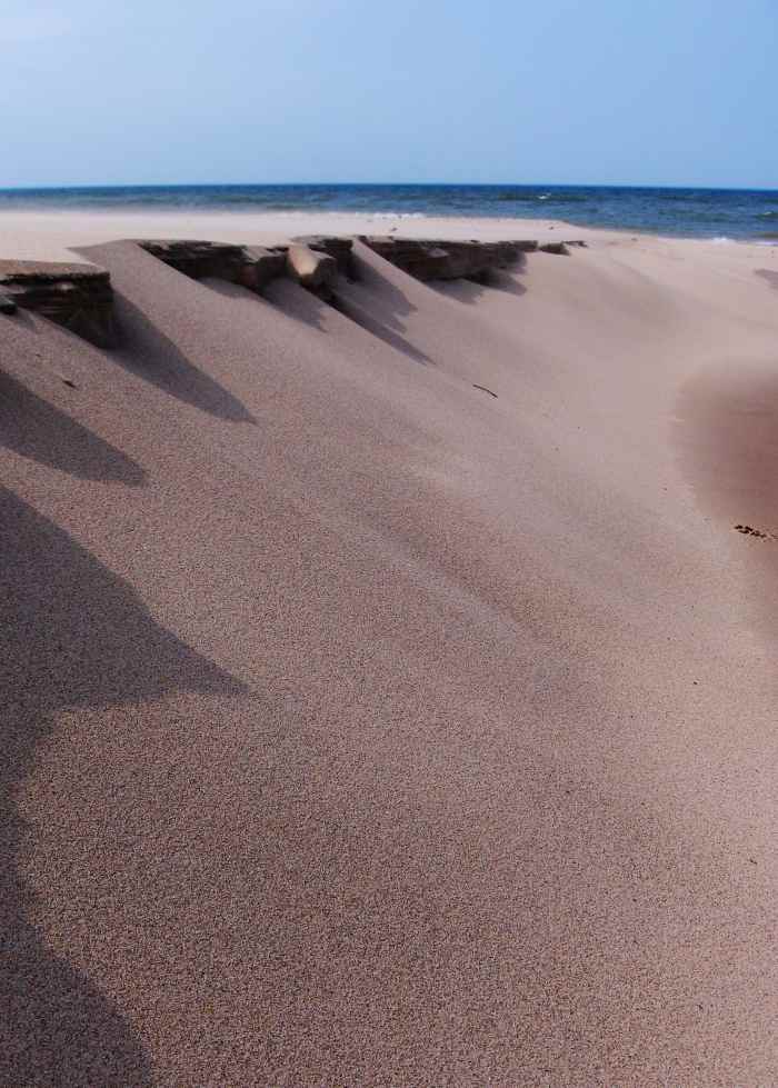 Winds of time and warm temperatures erase the sand sculptures shown above along Pier Cove Creek banks.
