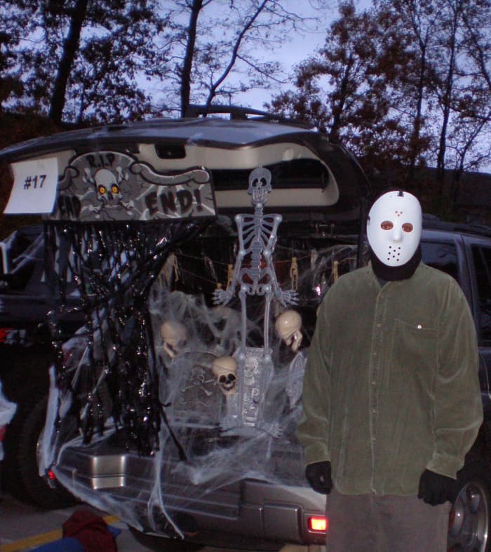 This adult dressed up as Jason Voorhees for Halloween and became a prop in his Trunk or Treat display.