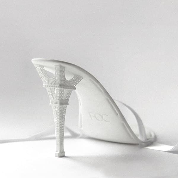 3D printed stiletto features intricate Eiffel Tower heel detail.