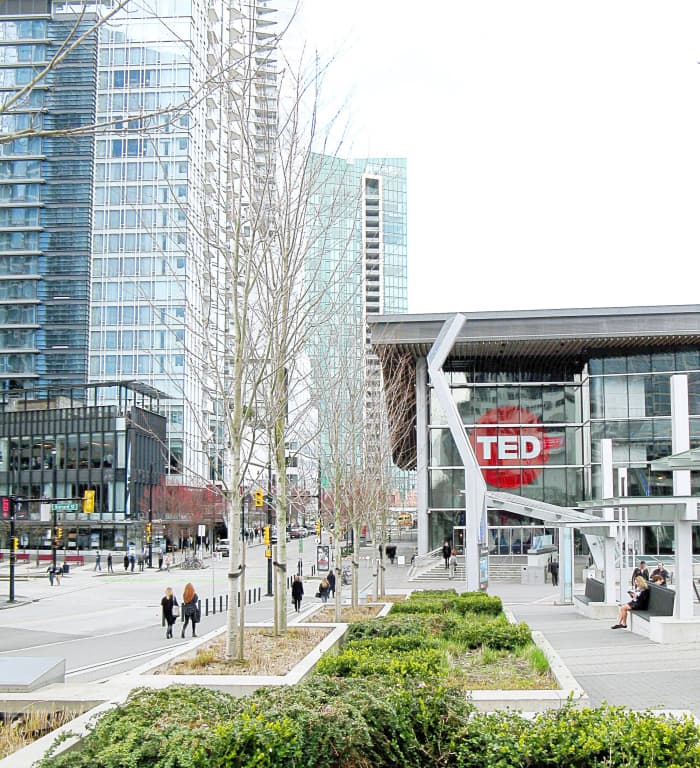 The western building of the Vancouver Convention Centre is located at Canada Place, which is located next to Burrard Inlet and a pier with a promenade.
