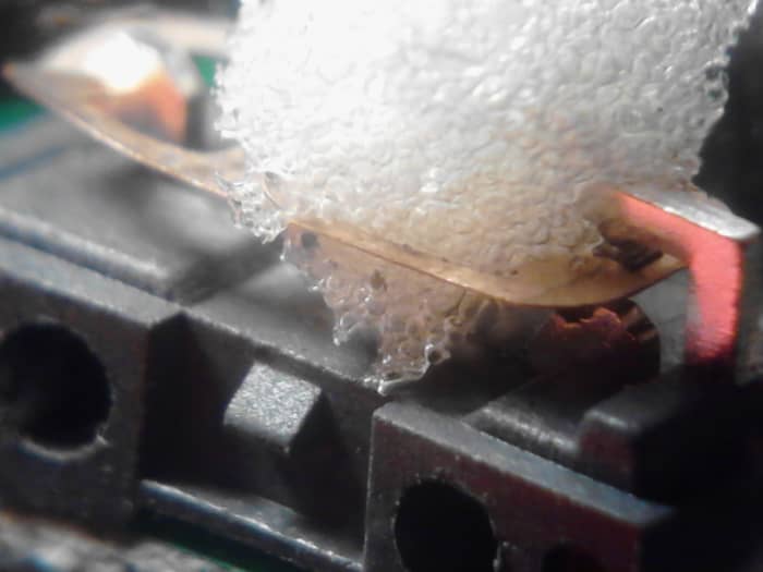 Start by using some tweezers to gently push/pull the piece of memory foam through this part of the switch. It must be done very carefully and it must be done on this part of the switch only!