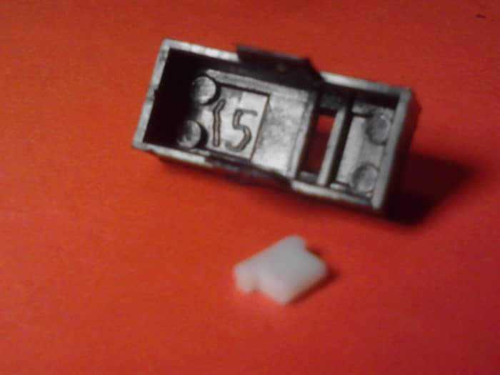 This is the switch cover removed. Notice the small white piece in the foreground. This is the part that presses the internal switch piece that makes the loud click sound we hate. Don't lose this or you will be in big trouble.