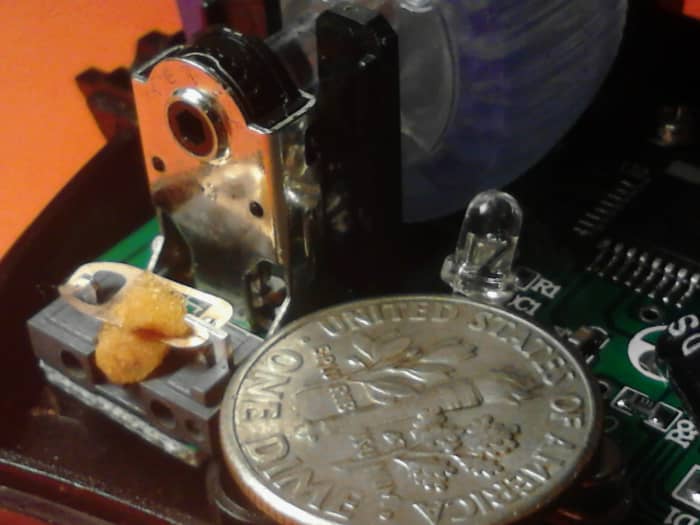 The small switch is on the left with a piece of orange memory foam already placed inside the switch. The dime is for size comparison. If you cannot work on something this small then get help or stop working on this until you are comfortable doing so.