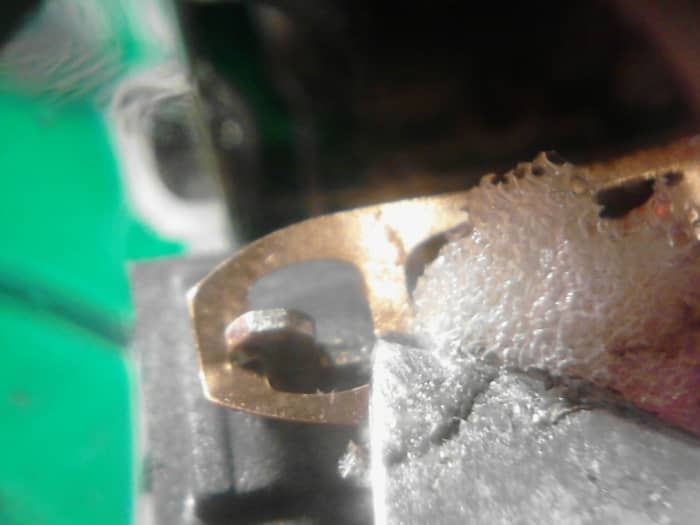 Using a knife or small pointed object, press down gently on the small strip of metal going across the metal switch tab. This is the contact point of the switch when it is pressed down.