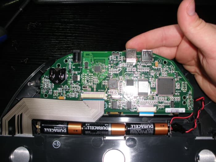 Gently lift the motherboard without putting any tension on the ribbon cables that are attached to it, and then remove the battery from its holder. Insert the new one positive or '+' side up and put everything back together.