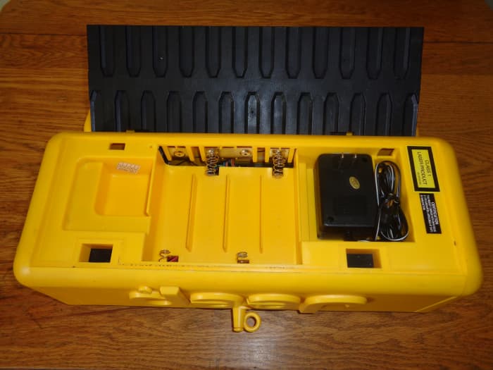The bottom plate comes off with two tabs and stores the power plug and houses the batteries.