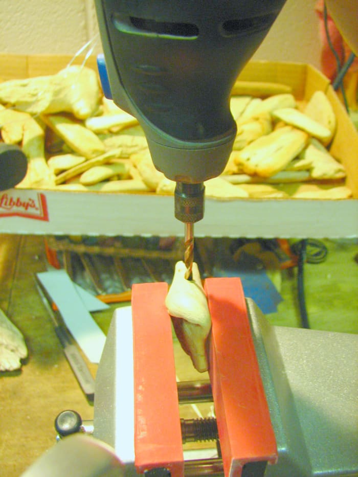 Clamp the selected driftwood in a vise or hold it with a pair of pliers when drilling with the rotary tool