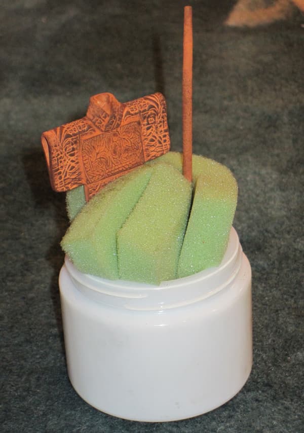 Copper clay pieces propped up vertically in a folded piece of foam sheet, using gravity to advantage while fresh clay additions or repaired breaks are drying.