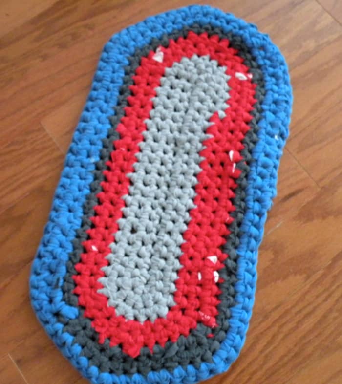 Photo of T-shirt rug in progress. This rug is going to be red, blue, and gray. I've used 4 T-shirts so far.