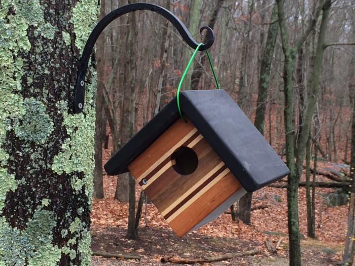 The front of this small hanging birdhouse was made by gluing together strips of different hardwoods including teak, mahogany, walnut and maple.