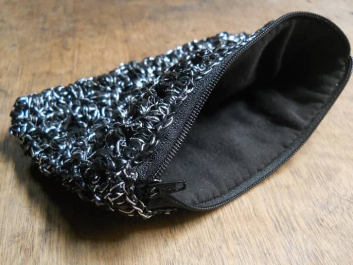 The zipper is attached to the crocheted pouch while the lining is attached to the zipper. But the zipper still protrudes. So it's not perfect!