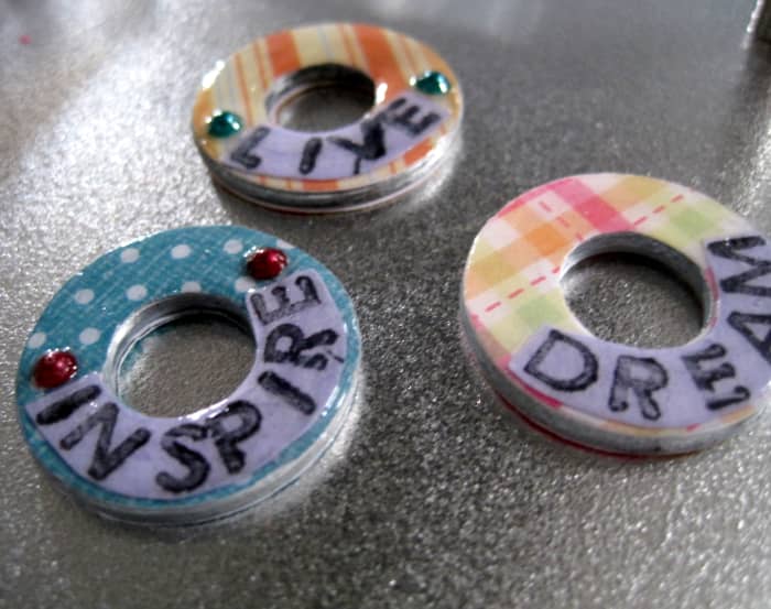 These are scrapbook paper-covered washers waiting to be made into pendants.