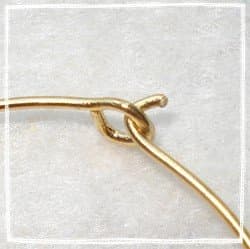 With the needle nose pliers, make a loop with one end of the wire. Bend the other side of the wire up to make a tab for your wine glass rings.