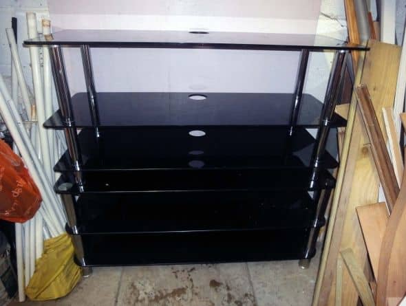 Using a couple of old glass TV stands, one stacked on top of the other in my workshop, as a temporary shelving storage solution for salvaged wood