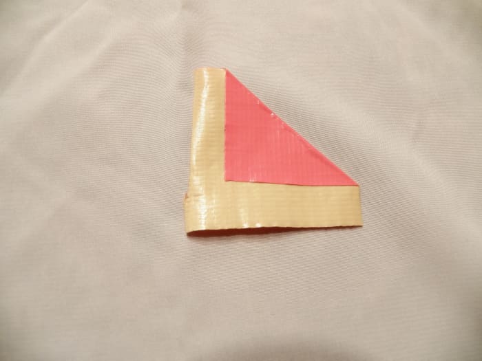 Step 2: fold right side down into a triangle. leave about 1/3 to 1/2 inch of duct tape uncovered.
