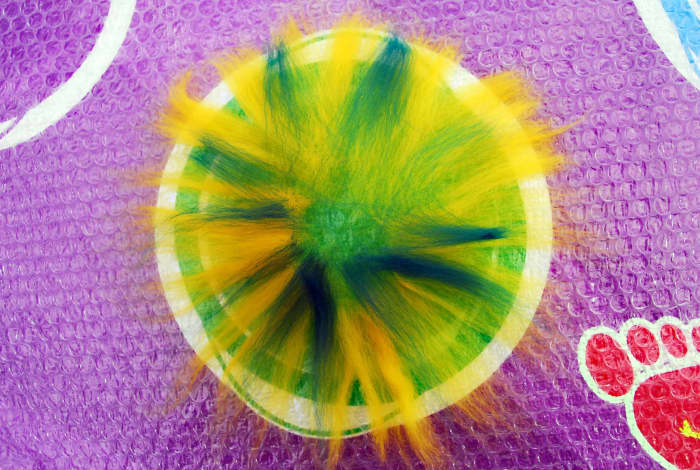Lay a sheet of bubble wrap down, smooth side up and then place your design down using thin fibers of wool over the whole circle