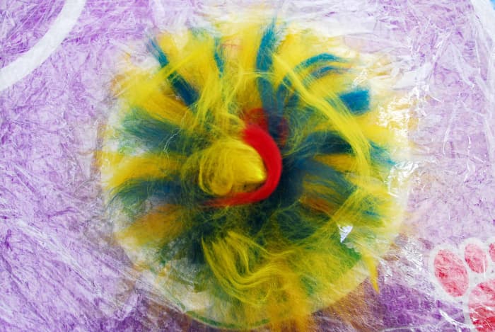 Lay down the last set of fibers with a little decoration on top. Try to ensure that if you use any silk threads etc., that you cover then with a few wool fibers to ensure that they do not detach themselves from the rest of the wool.