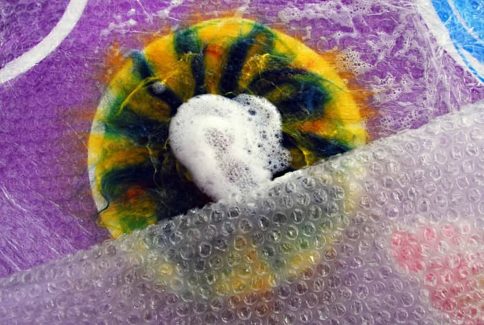 Remove the piece of netting and place a little more soapy water in the center and place a piece of bubble wrap over the whole thing. Press down and begin to rub the project carefully
