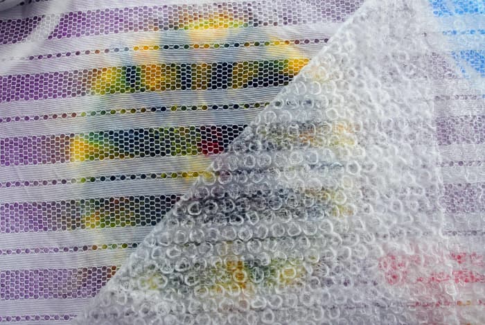 Cover with bubble wrap. This will help disperse the water throughout the layers as you gently press down on the fibers