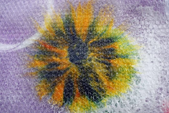 Turn project over and begin rubbing firmly. The idea is to ensure that all layers are felted but separately throughout the layers. The central core should hold the whole flower together with the layers separate.