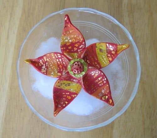 Bake the flower in an oven-safe Pyrex custard cup on top of polyester fiberfill batting. This supports the curved petals as they cure.