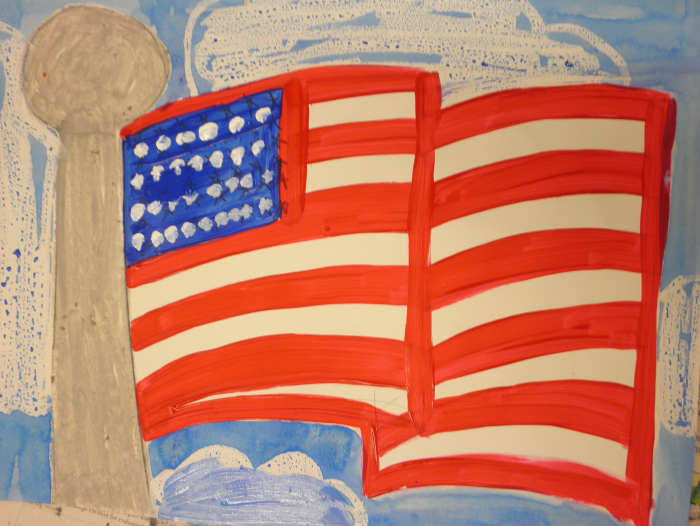 Painting of an American flag with acrylic paint. Charisse added clouds to her American flag painting. The clouds were done with oil pastel then a watercolor wash was added to the sky. Beautiful job!