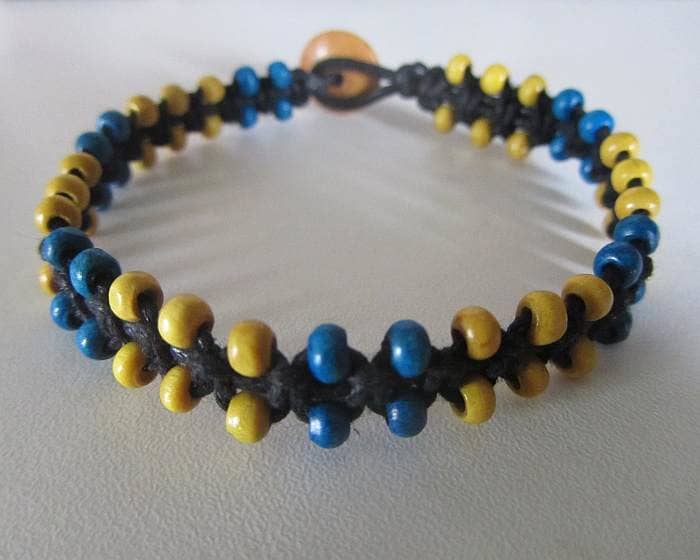Macramé jewellery can be made using no metal components at all. This particular design using cotton cord and wooden beads. A clasp is created using a cord loop and a button.